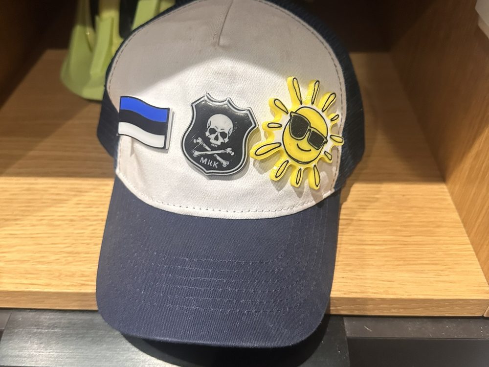 Kolm embleemi sinivalgel mütsil